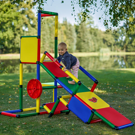Toddler climbing the ramp to the play tower of QUADRO Evolution Classic, Multiwheel on the left