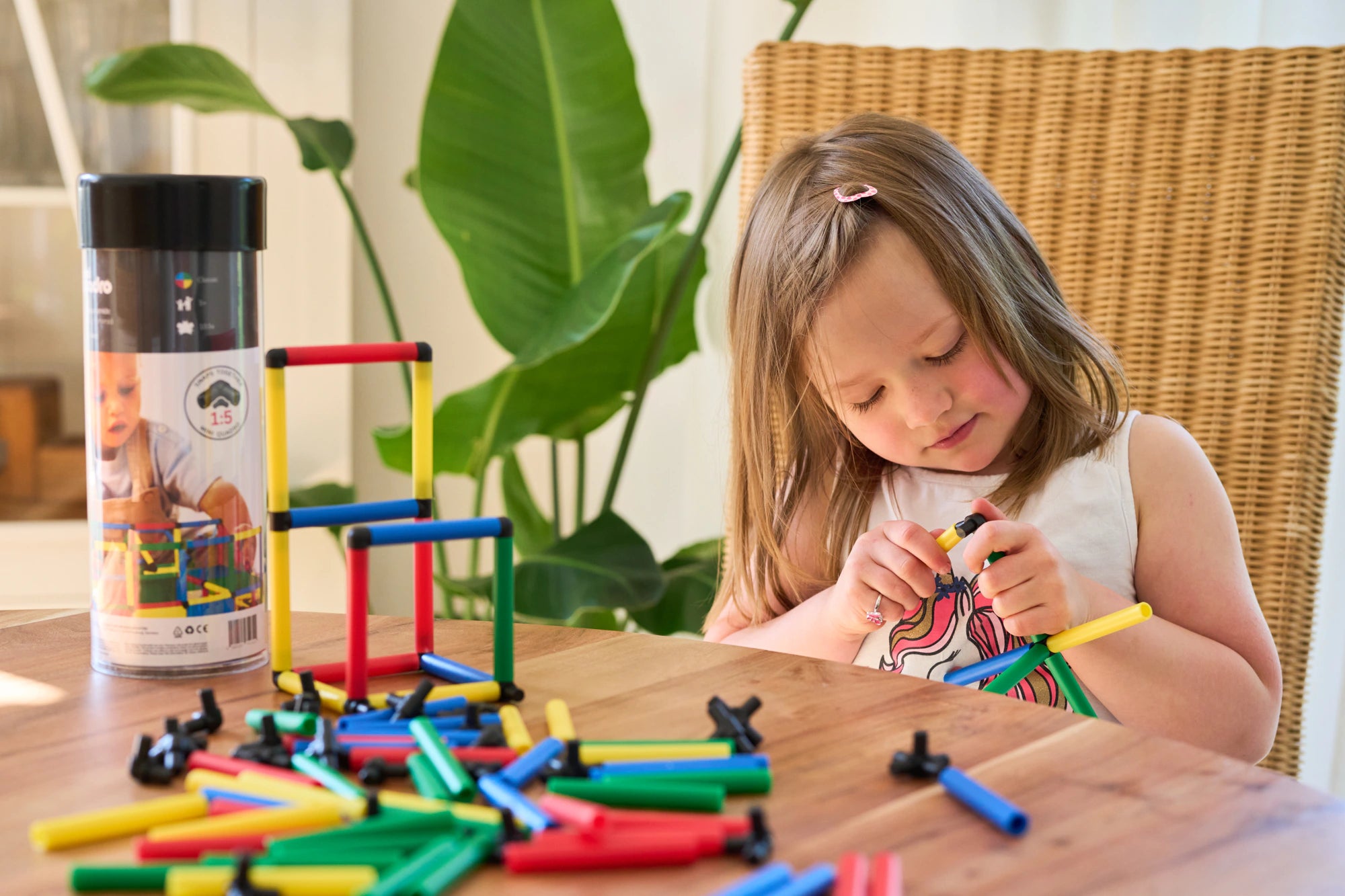 Girl connecting yellow and black QUADROmini parts at a table