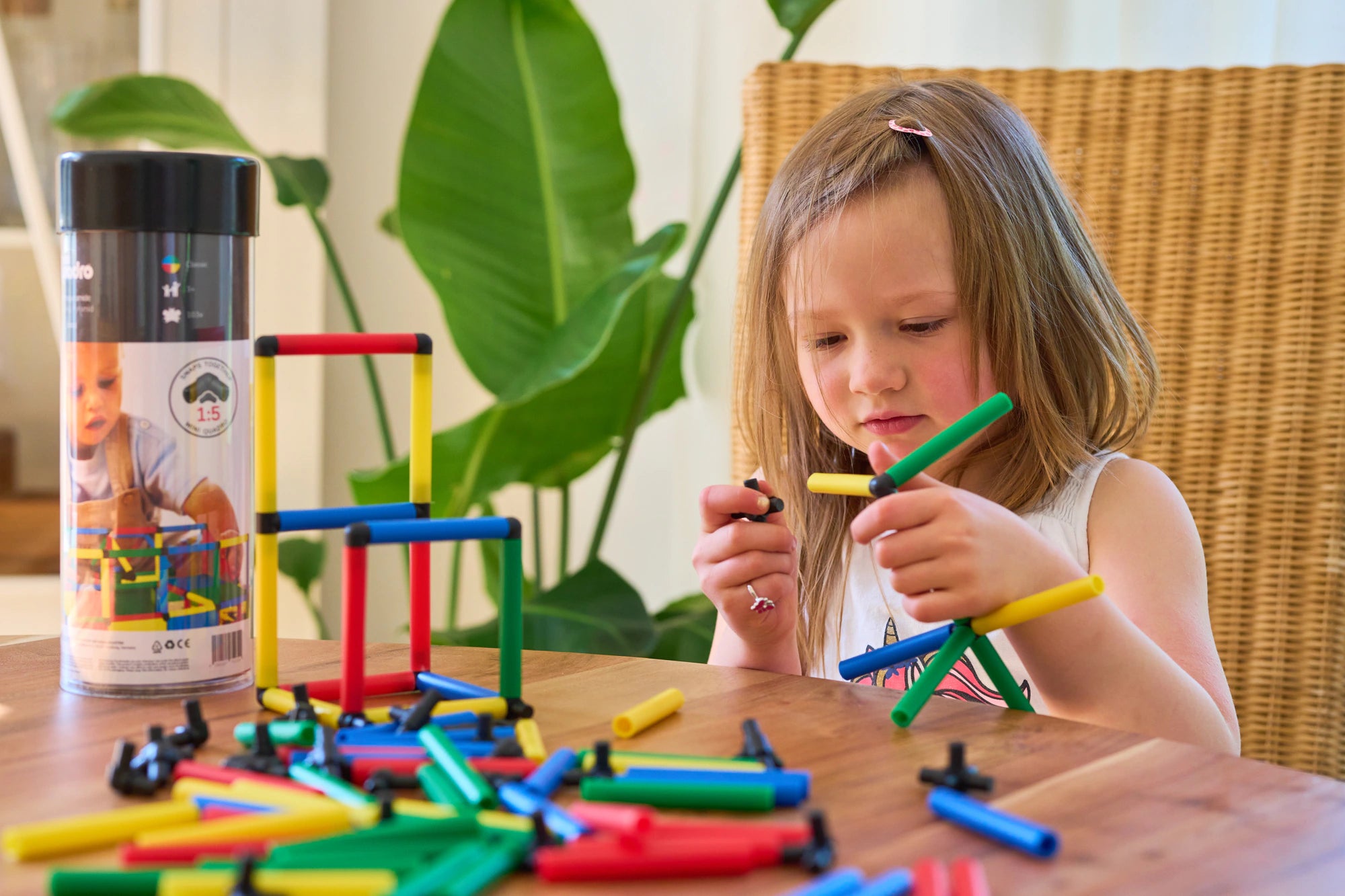 Girl examining a green QUADROmini construction while building