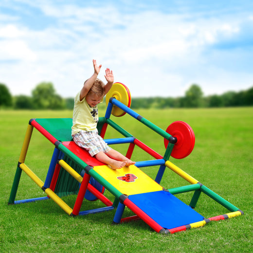 Barefoot child sliding down the ramp of QUADRO Basic Classic with arms raised, Multiwheels on both sides