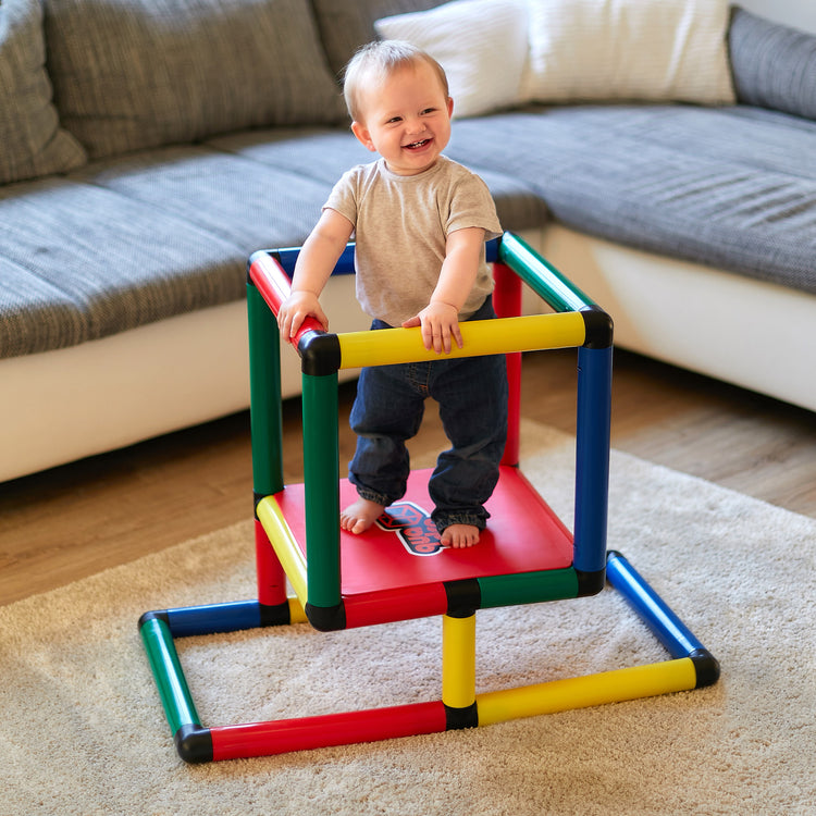 Małe dziecko stoi na platformie QUADRO Beginner Classic i trzyma się balustrady